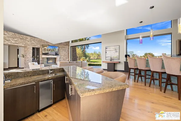 a dining room with furniture and a floor to ceiling window