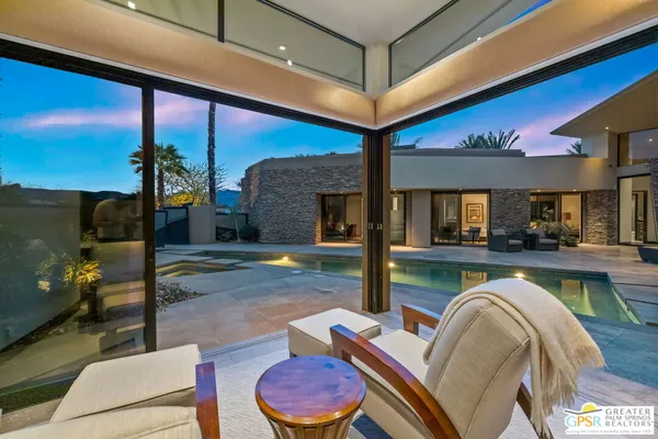 a swimming pool with outdoor seating and yard