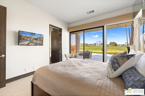 a spacious bedroom with a bed and a lamp