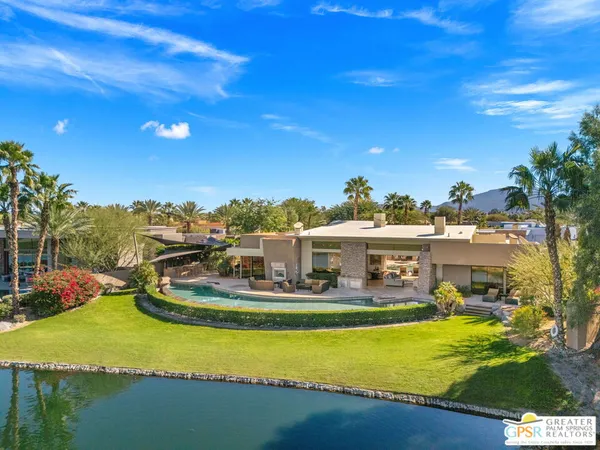 an aerial view of a house with a swimming pool and outdoor seating
