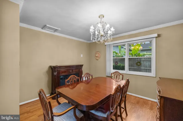 a view of a dining room with furniture a chandelier and wooden floor