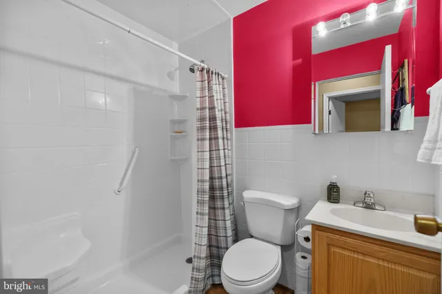 a bathroom with a toilet sink vanity and shower