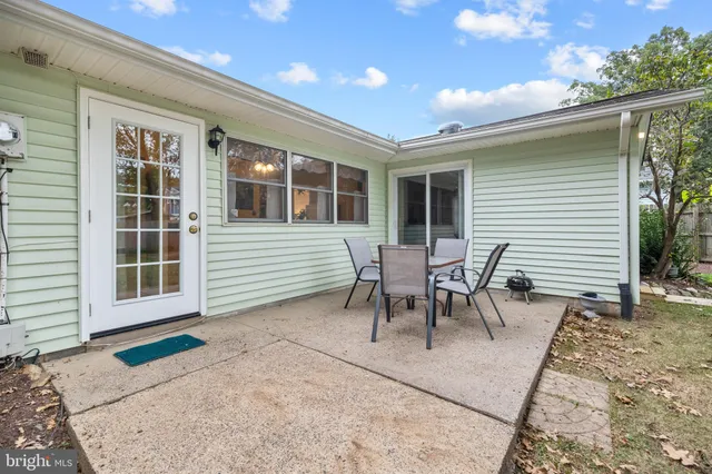 a view of a house with a patio and a yard