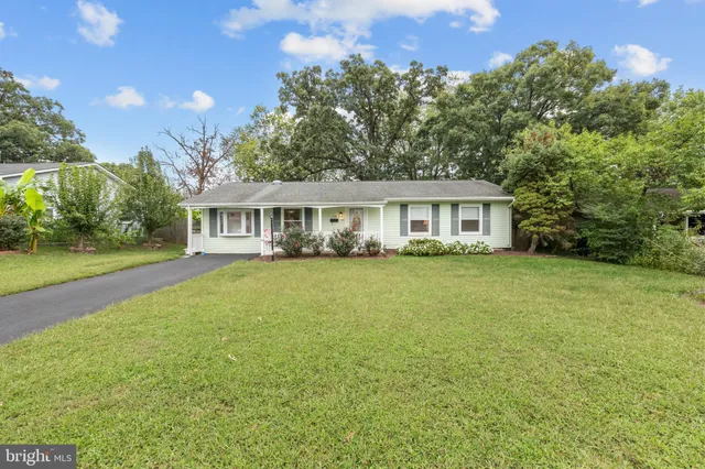 a view of house with yard and outdoor seating