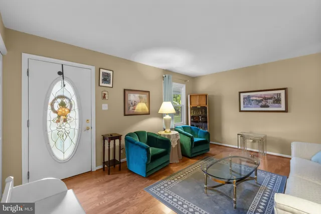 a living room with furniture a rug and wall paintings