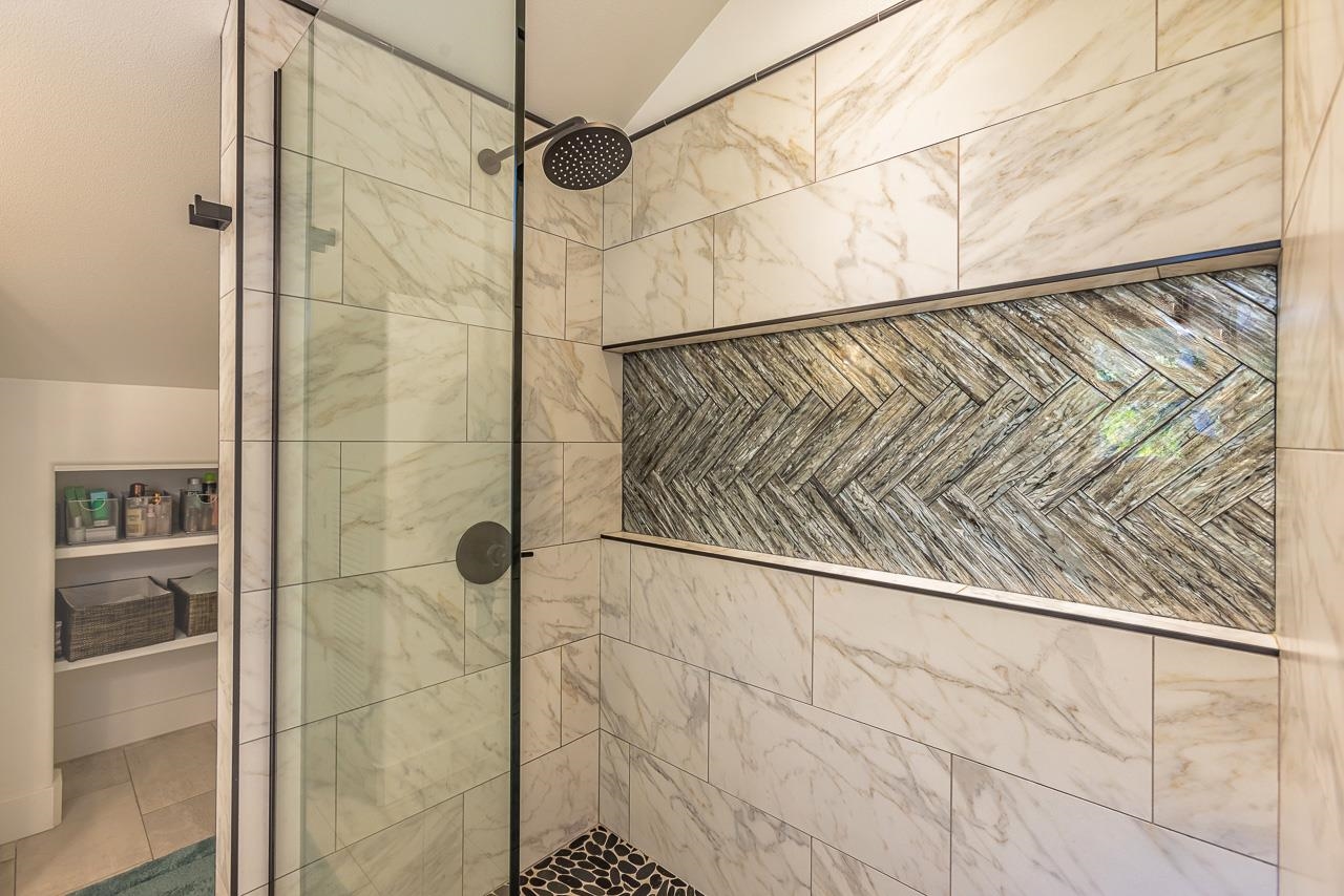 555 North Holokai Road Haiku, HI 96708 - Photo 27 of 50 The beautiful shower in the primary bath features a stone floor that mimics the sink's backsplash