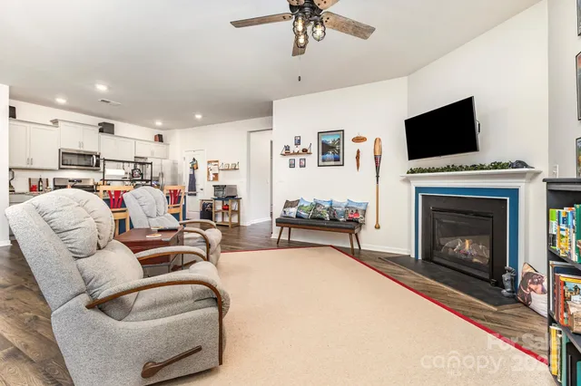a living room with furniture a fireplace and a flat screen tv