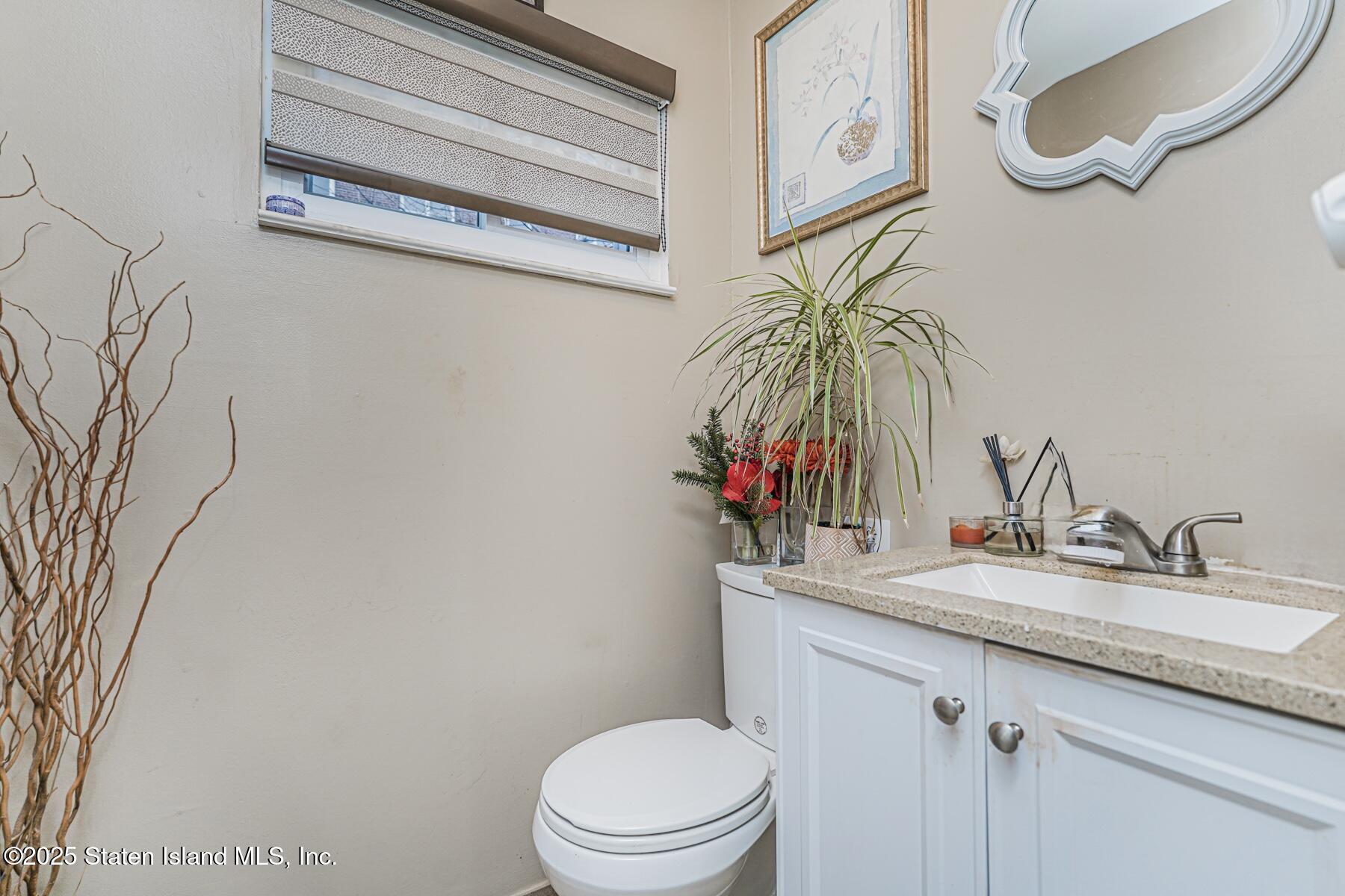 121 Clark Lane Staten Island, NY 10304 - Photo 14 of 18 a bathroom with a granite countertop sink a toilet and a mirror