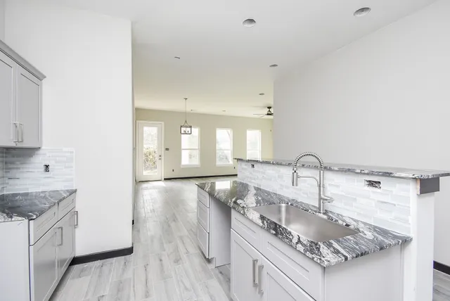 a kitchen with stainless steel appliances granite countertop a sink stove and cabinets