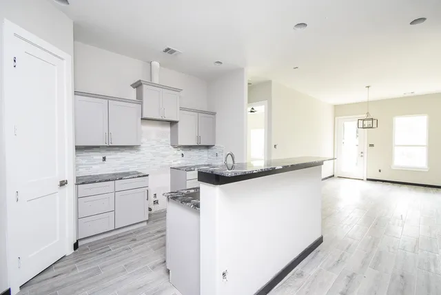 a kitchen with a sink a stove and cabinets