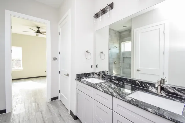 a bathroom with a granite countertop sink and a mirror