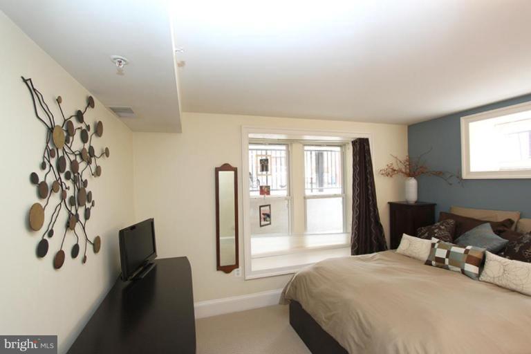 1750 16th Street Northwest, Unit 4 Washington, DC 20009 - Photo 19 of 20 a bedroom with a bed flat screen tv and a window