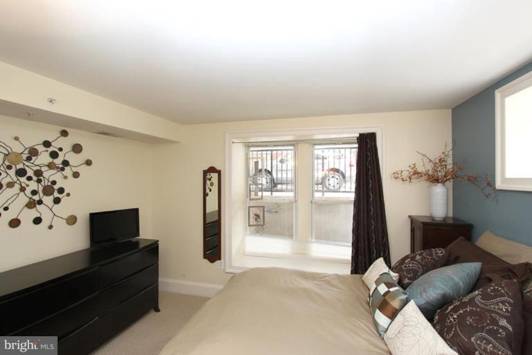 1750 16th Street Northwest, Unit 4 Washington, DC 20009 - Photo 20 of 20 a living room with furniture a flat screen tv and a floor to ceiling window