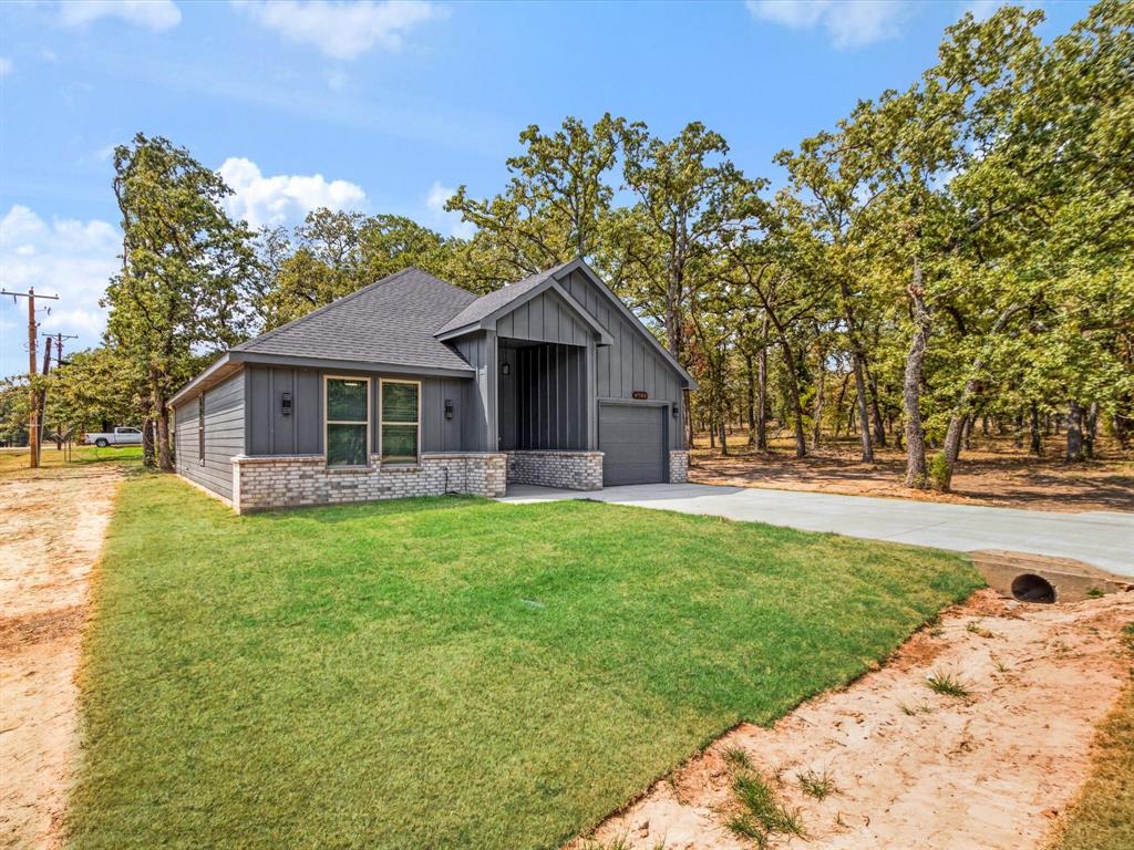 4705 Point La Vista Road Malakoff, TX 75148 - Photo 3 of 40 Modern exterior with vertical and horizontal siding, brick accents, a gabled roof, and an attached garage