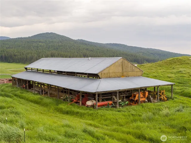 a view of a big house with a big yard and large trees