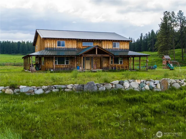 a front view of a house with garden and trees