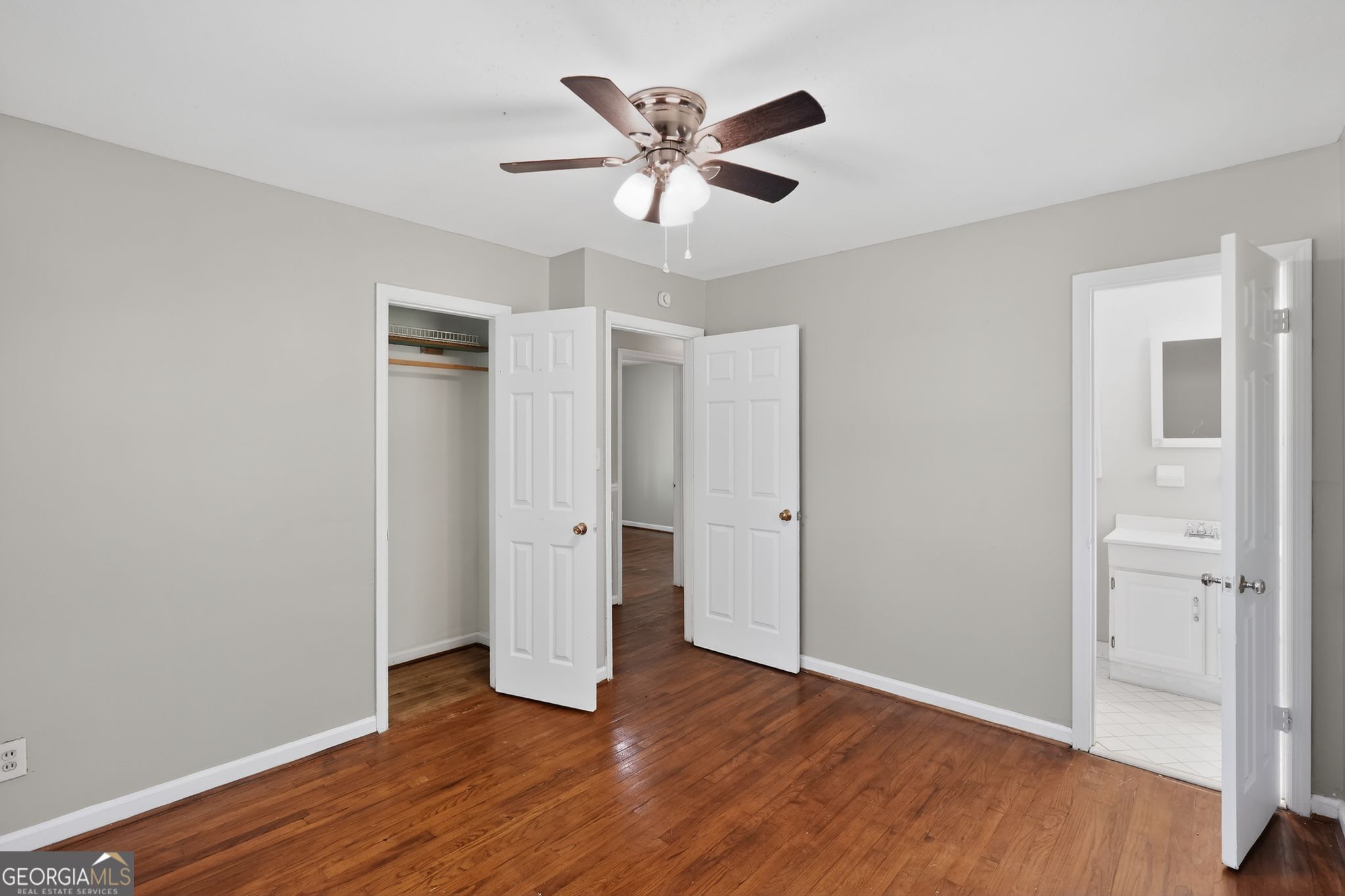 1071 Luther Drive Southwest Mableton, GA 30126 - Photo 17 of 27 an empty room with wooden floor and a ceiling fan