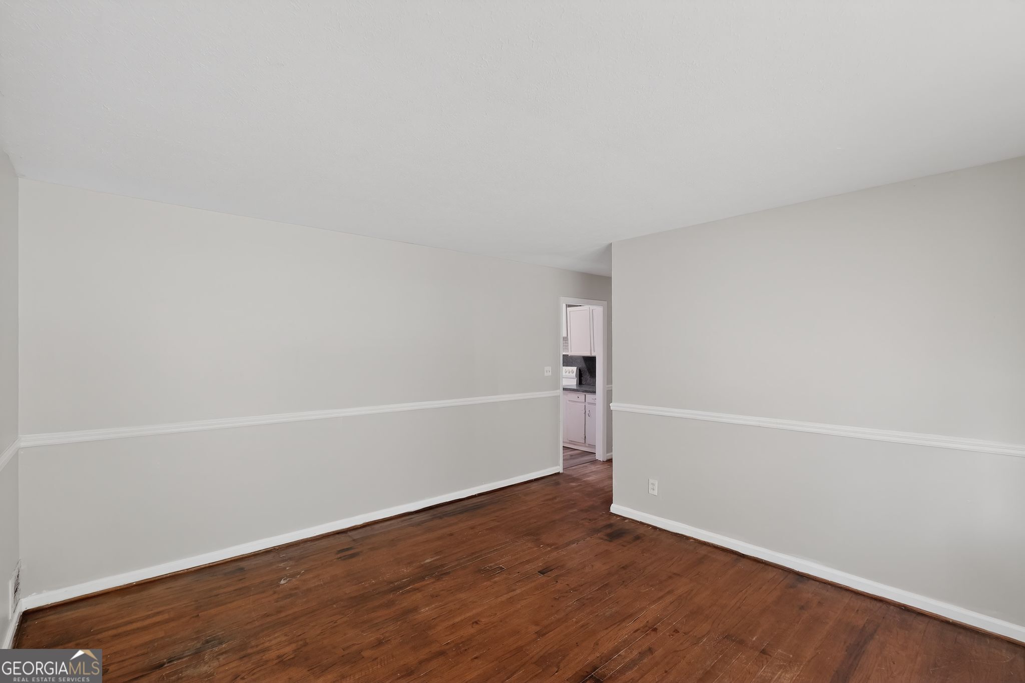 1071 Luther Drive Southwest Mableton, GA 30126 - Photo 9 of 27 an empty room with wooden floor and white walls
