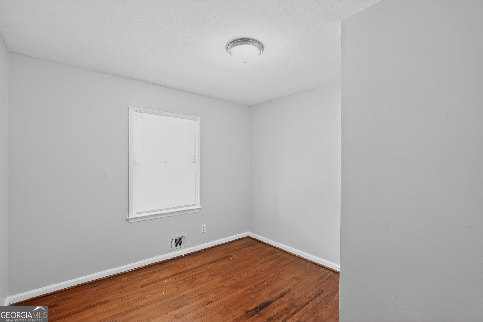 1071 Luther Drive Southwest Mableton, GA 30126 - Photo 10 of 27 a view of an empty room with wooden floor and a window