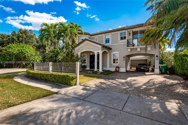 a front view of a house with a garden and a tree