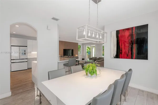 a living room with furniture a wooden floor and kitchen view