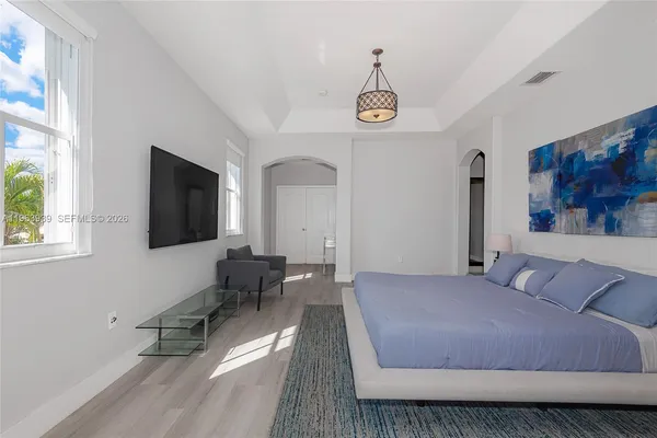 a bedroom with a bed and a chandelier fan