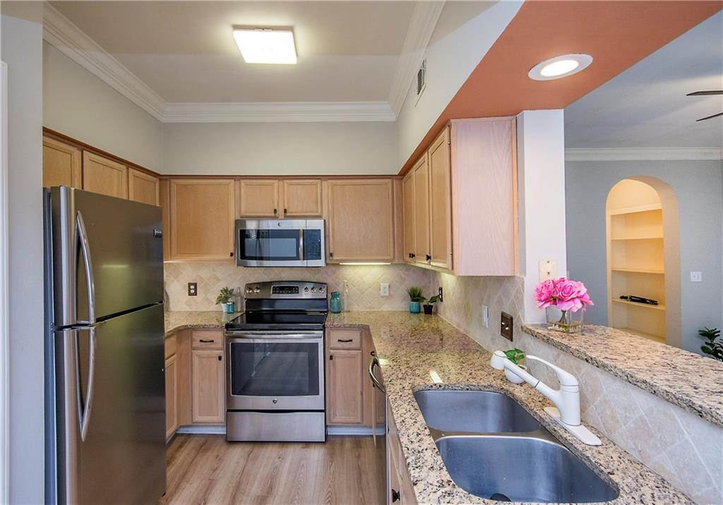 a kitchen with stainless steel appliances granite countertop a refrigerator sink and stove