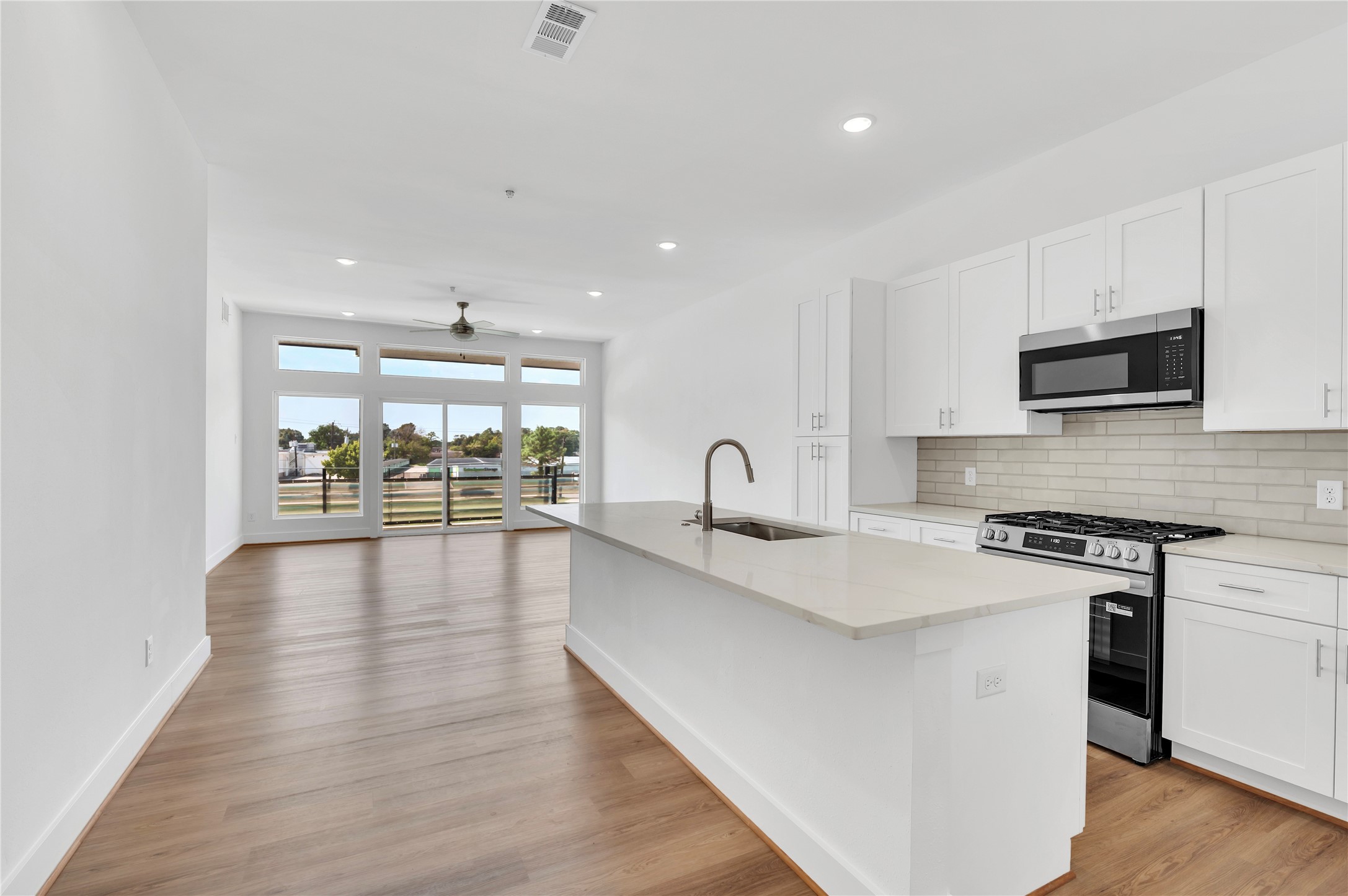 119 Kirby Road, Unit 5205 Seabrook, TX 77586 - Photo 30 of 46 Bright and open kitchen with modern appliances, sleek cabinetry, and a spacious island, seamlessly flowing into a sunlit living area with large windows and beautiful views.