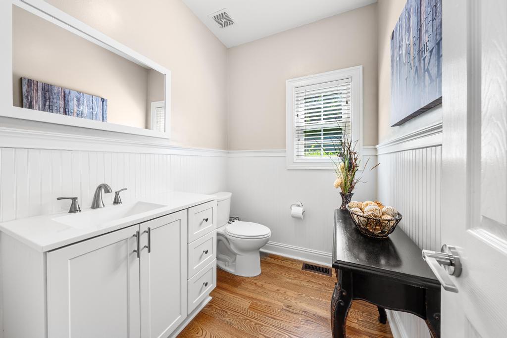 217 Maret Road Townville, SC 29689 - Photo 14 of 35 A well-lit 1/2 bath features hardwood flooring and a pristine white vanity with ample storage.