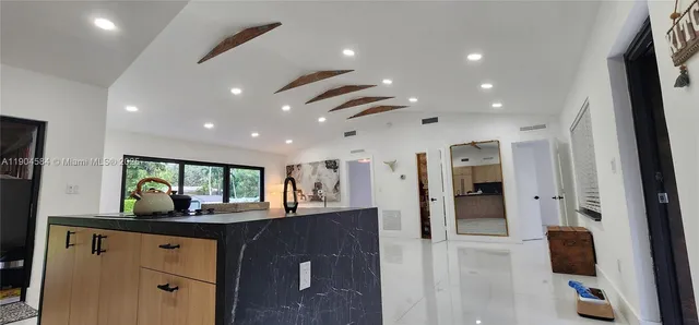 a kitchen with stainless steel appliances kitchen island granite countertop a refrigerator and a sink