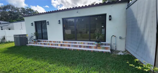 a view of a house with backyard and sitting area
