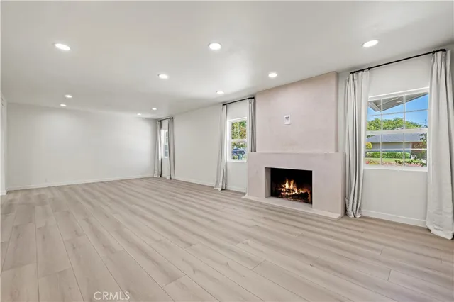 a view of a livingroom with a fireplace wooden floor and window