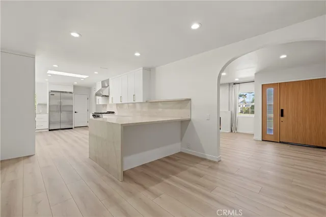 a large kitchen with stainless steel appliances granite countertop a large counter top and a wooden floors