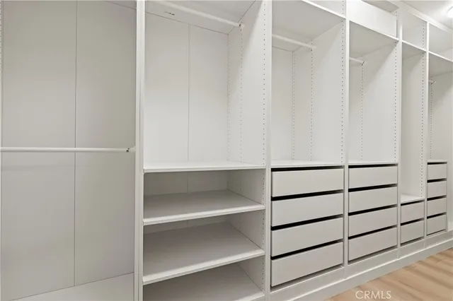 a view of walk in closet with empty racks