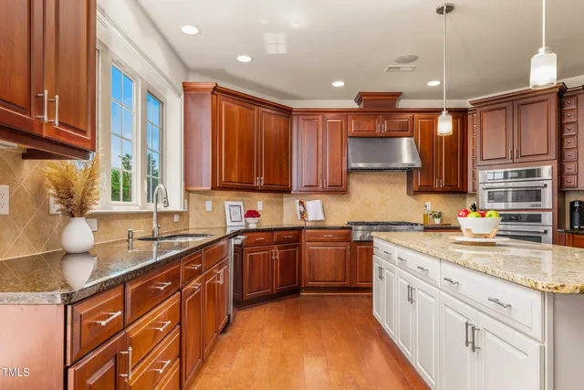 a kitchen with stainless steel appliances granite countertop wooden cabinets a sink and dishwasher