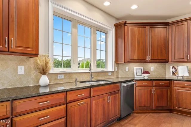a kitchen with stainless steel appliances wooden cabinets a sink and a window
