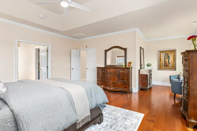 a spacious bedroom with a bed and wooden floor