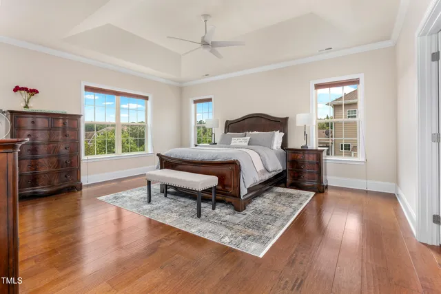 a bedroom with a bed a dresser and wooden floor