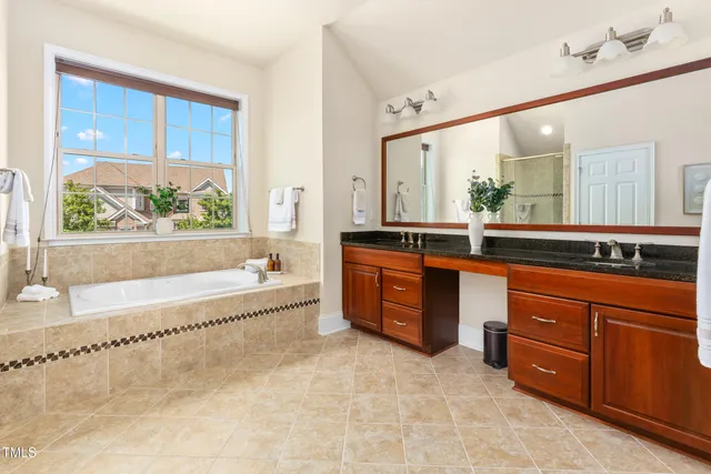 a spacious bathroom with a tub sink and mirror