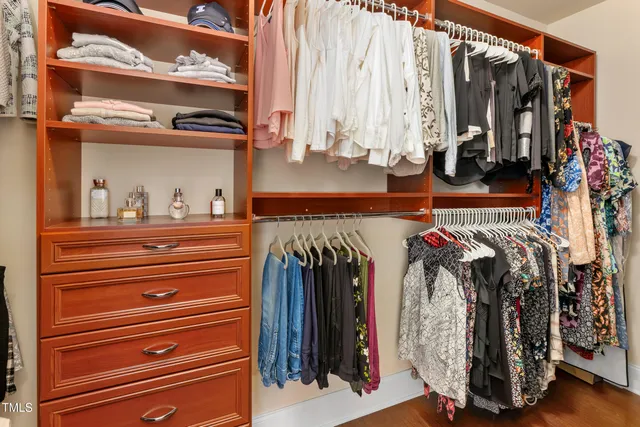 a view of walk in closet with clothes and shoes