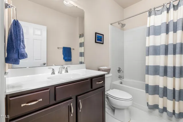 a bathroom with a granite countertop sink a toilet and a mirror