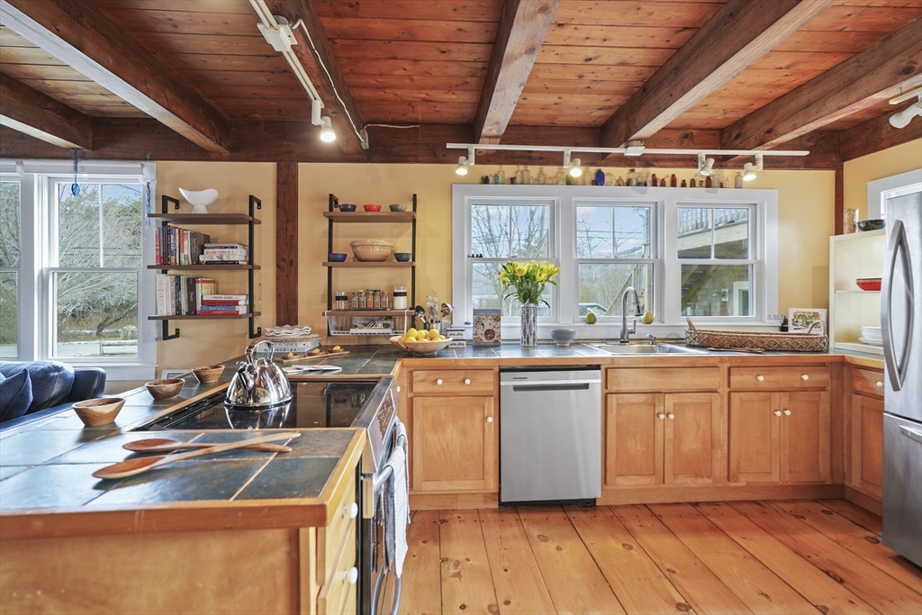 44 Planting Field Way Edgartown, MA 02539 - Photo 11 of 32 a kitchen with stainless steel appliances granite countertop a sink stove and wooden cabinets