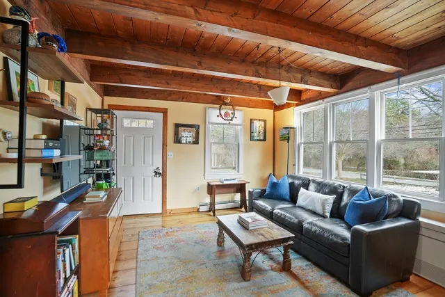 a bedroom with a bed large window with table and chair