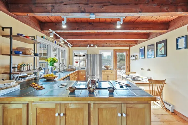 a kitchen with stainless steel appliances granite countertop a sink window and cabinets