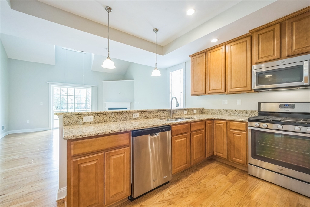 53 Baldwin Road, Unit 1401 Billerica, MA 01821 - Photo 14 of 32 a kitchen with granite countertop cabinets stainless steel appliances and a sink