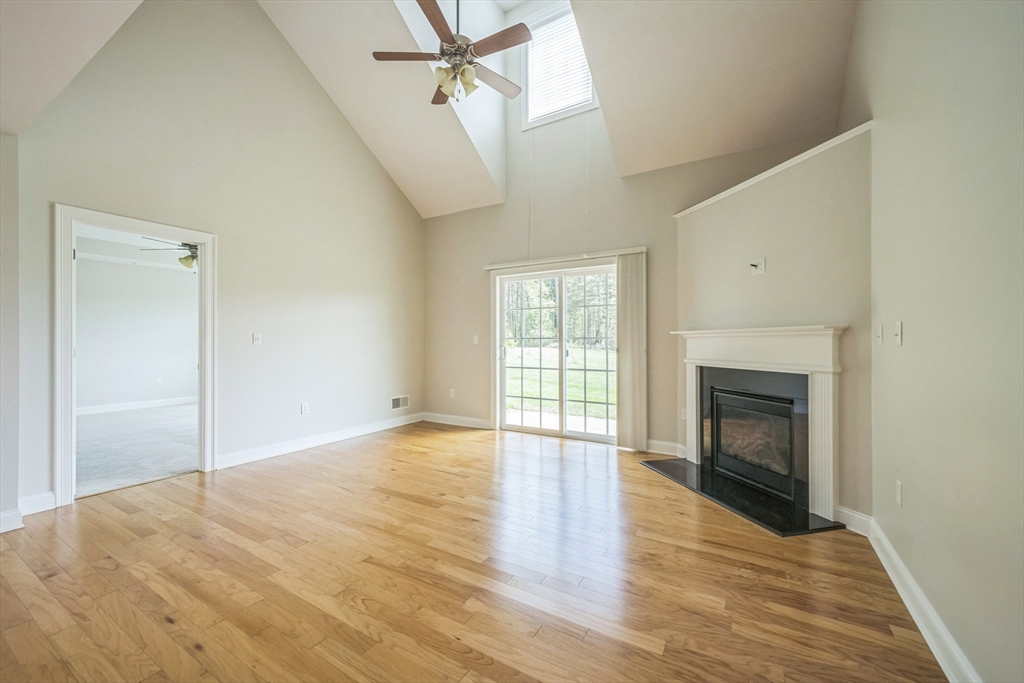 53 Baldwin Road, Unit 1401 Billerica, MA 01821 - Photo 7 of 32 an empty room with wooden floor fireplace and windows
