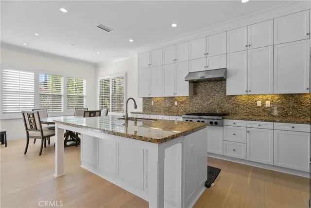 a kitchen with granite countertop sink window and white cabinets