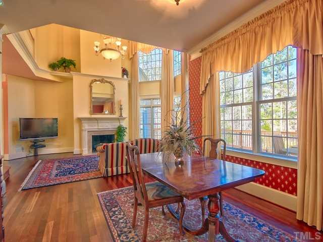 14412 Possum Track Road Raleigh, NC 27614 - Photo 7 of 25 a living room with fireplace furniture and a floor to ceiling window