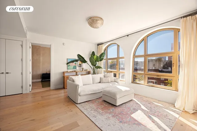 a living room with furniture a flat screen tv and a floor to ceiling window