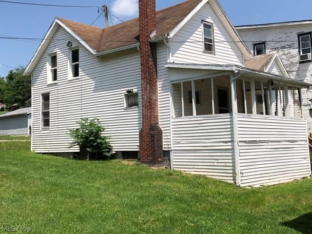 11978 Clay Pike Road Buffalo, OH 43772 - Photo 2 of 6 View of side of home with covered porch and a lawn